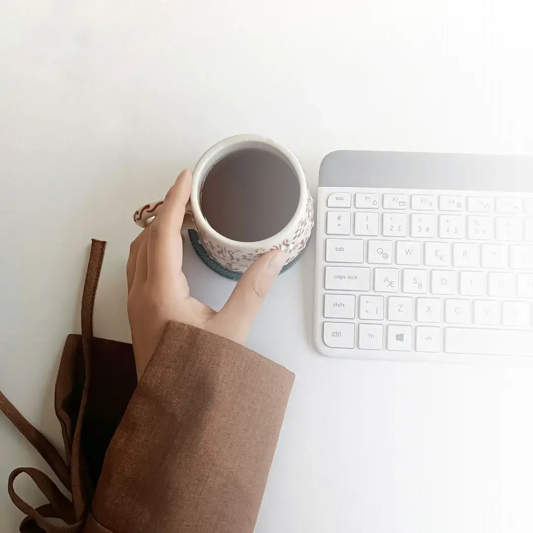 femme qui boit son café devant son ordinateur
